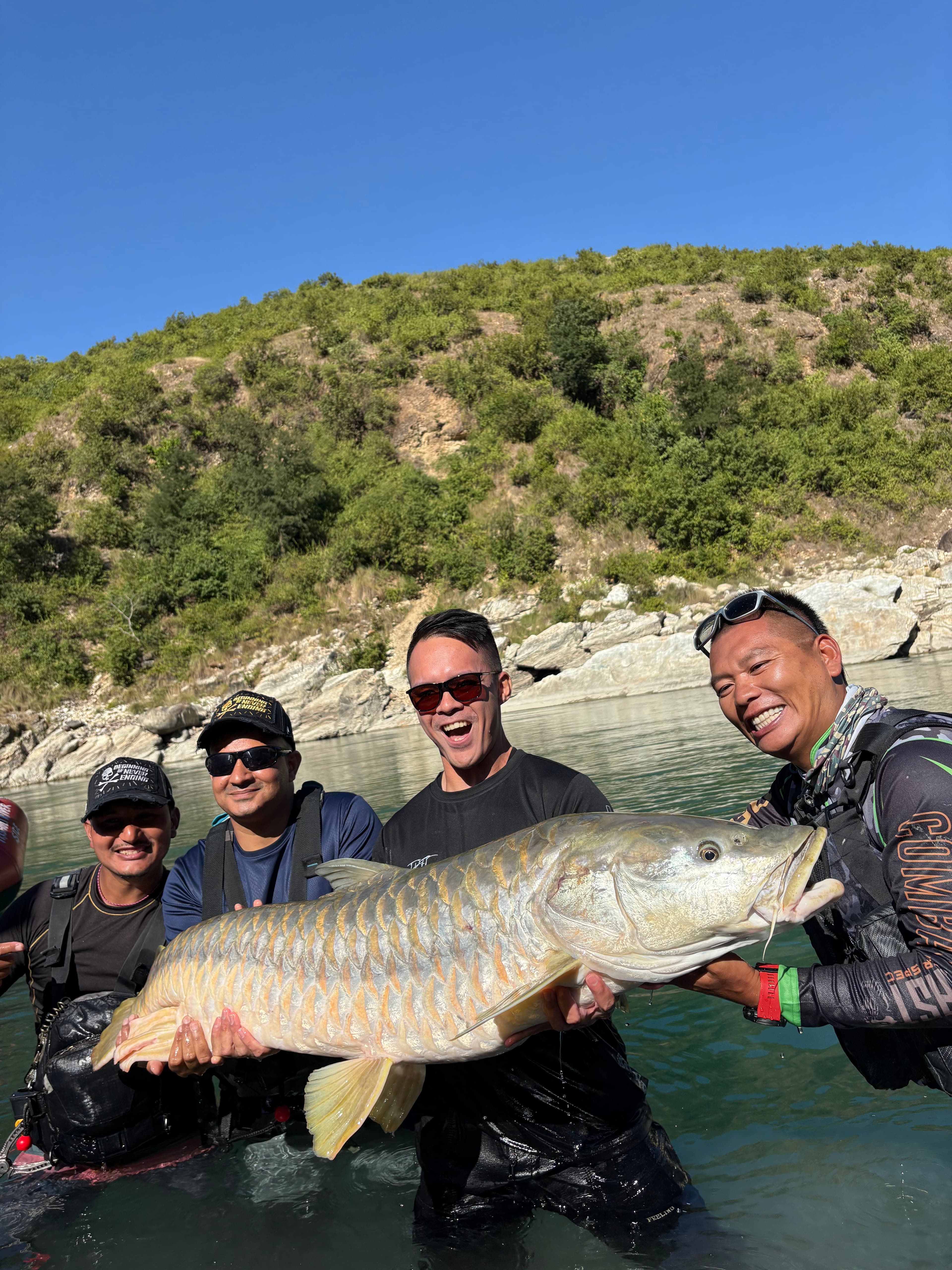 Guests holding a large fish in the river